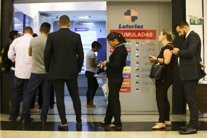 Apostadores fazem fila em casa lotérica. A Caixa Econômica Federal sorteia hoje (08) as seis dezenas do concurso 2.149 da Mega-Sena acumulada, que deve pagar um prêmio de R$ 170 milhões. (Foto: Marcelo Camargo/Agência Brasil).
